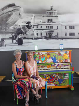 Dames assises au piano à l'aéroport
