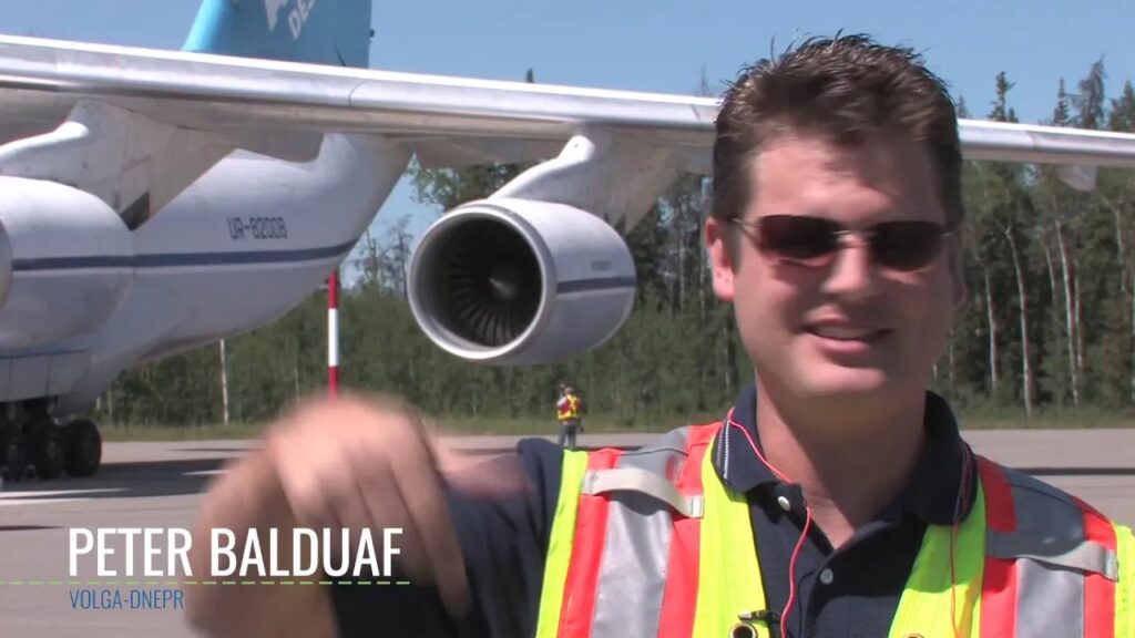 Man in front of a large plane parked at the airport